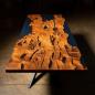 Preview: Ein Esstisch aus Massivholz mit lebender Kante umhüllt in blau schimmernden Kunstharz