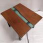 Preview: Couchtisch aus Massivholz und Epoxid auf einem Metallgestell.