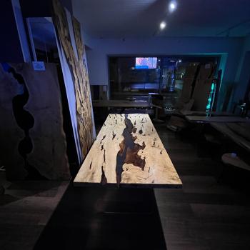 Ein wunderschöner Tisch aus einer sehr lebendigen, kontrastreichen Hainbuche, umhüllt und schwebend im transparenten Gewand des Epoxidharzes, getragen durch ein Gestell aus einem gehärteten 2 cm starken Glas.