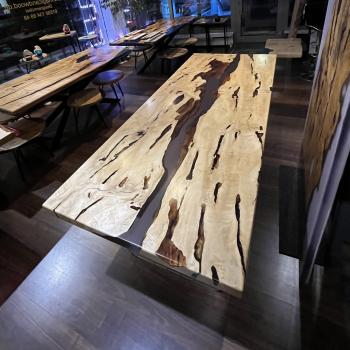 Ein wunderschöner Tisch aus einer sehr lebendigen, kontrastreichen Hainbuche, umhüllt und schwebend im transparenten Gewand des Epoxidharzes, getragen durch ein Gestell aus einem gehärteten 2 cm starken Glas.