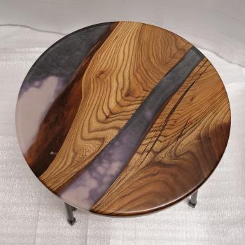 Couchtisch aus Massivholz und Kunstharz auf einem Metallgestell.
