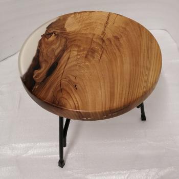 Couchtisch aus Massivholz und Epoxid auf einem Metallgestell.