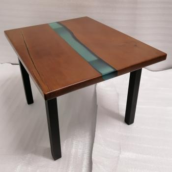 Couchtisch aus Massivholz und Epoxid auf einem Metallgestell.
