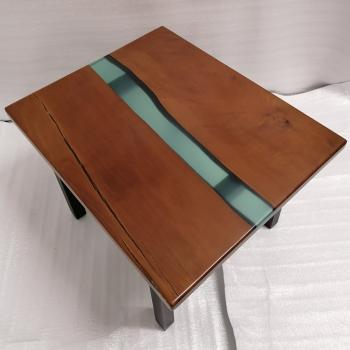 Couchtisch aus Massivholz und Epoxid auf einem Metallgestell.