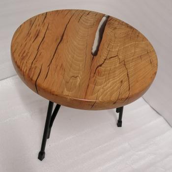 Couchtisch aus Massivholz und Epoxid auf einem Metallgestell.