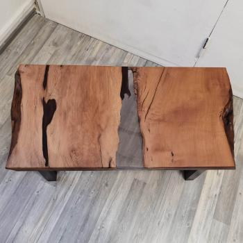 Preview: Couchtisch aus Massivholz und Kunstharz auf einem Metallgestell.