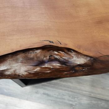 Couchtisch aus Massivholz und Kunstharz auf einem Metallgestell.