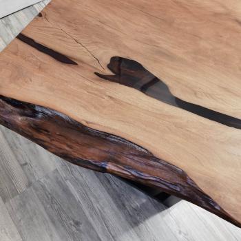 Couchtisch aus Massivholz und Kunstharz auf einem Metallgestell.