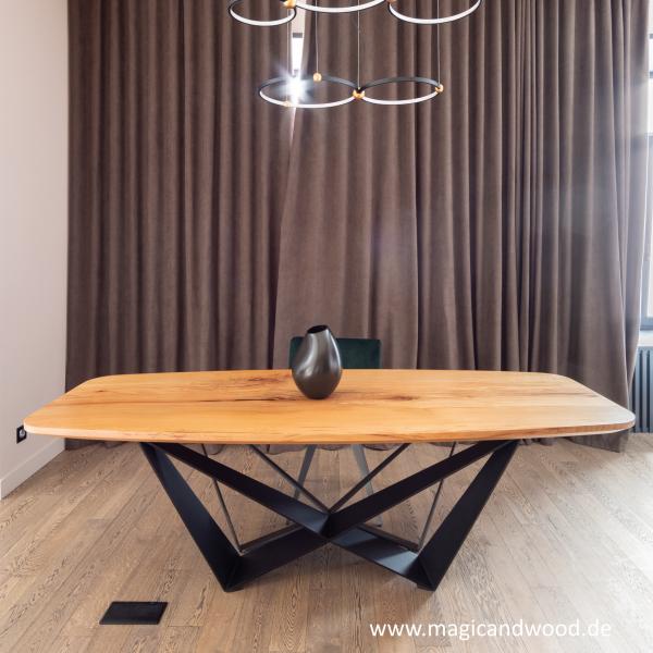 Ein Esstisch aus Massivholz auf einem futuristischen Metallgestell mit einer schweizer Kante.