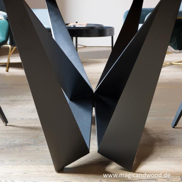 Ein Esstisch aus Massivholz auf einem futuristischen Metallgestell mit einer schweizer Kante.